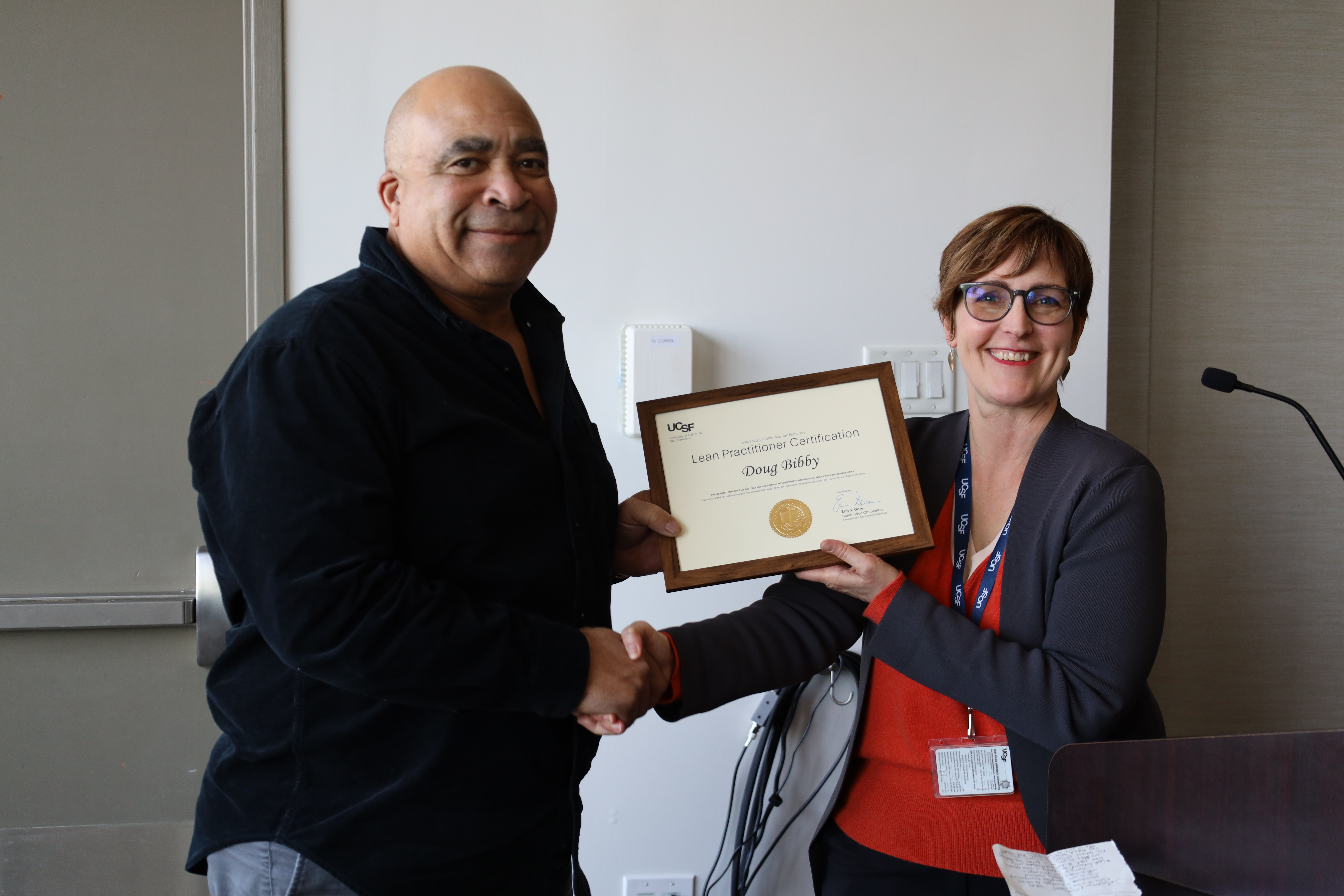 Doug Bibby receiving his Lean Practitioner Certificate from Stephanie Metz