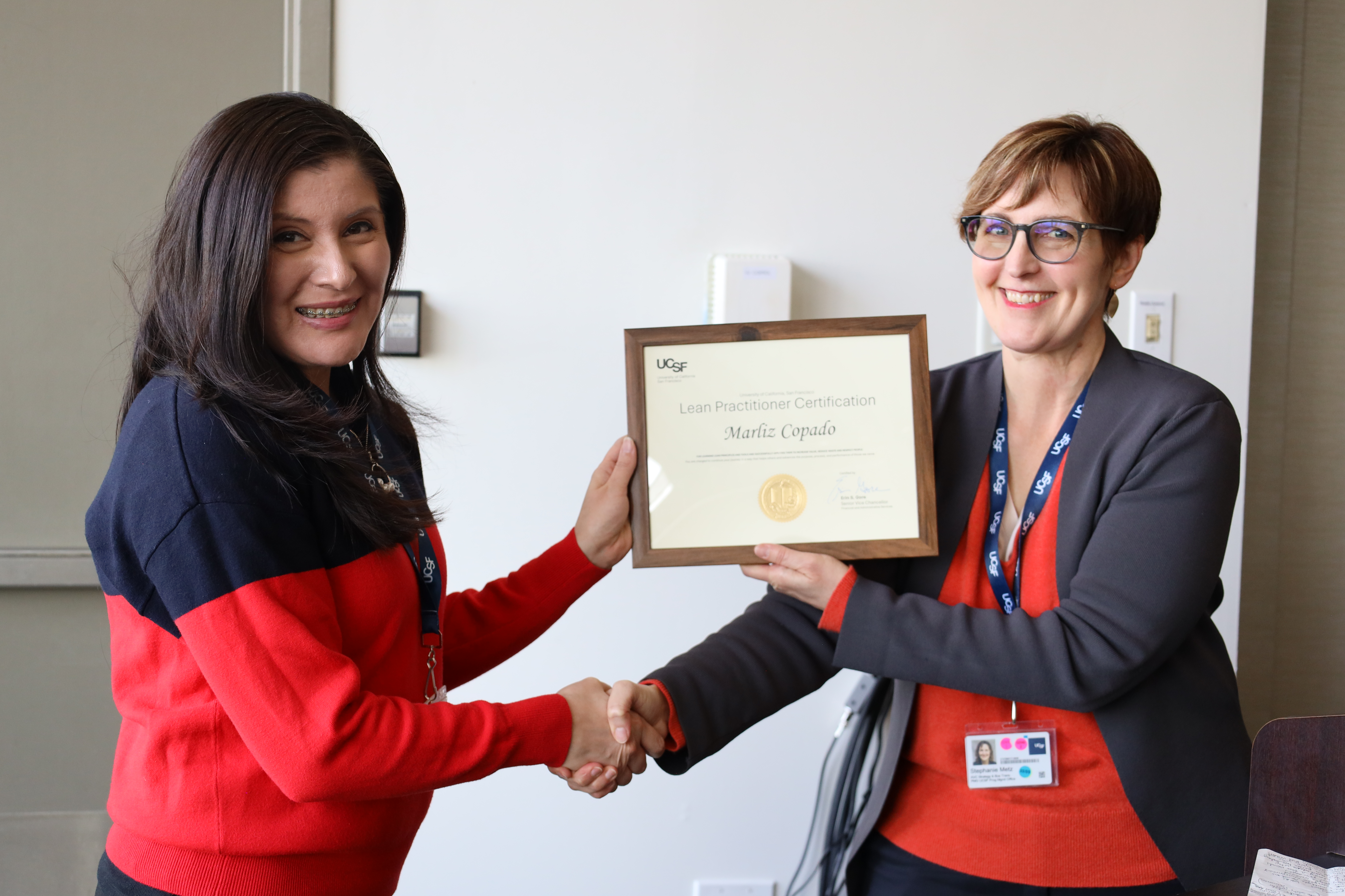 Marliz Copado receiving her Lean Practitioner Certificate from Stephanie Metz