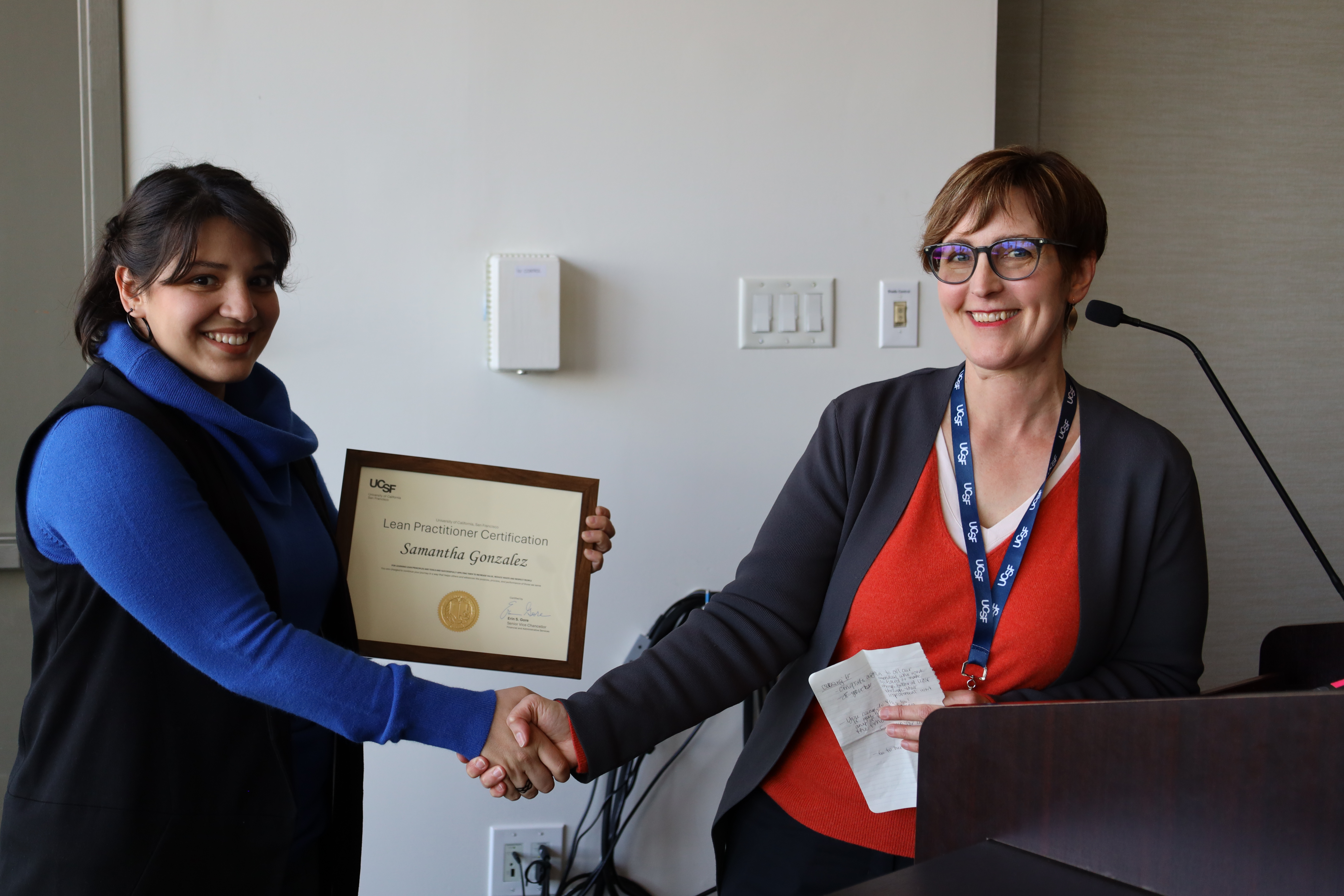 Sami Gonzalez recieving her Lean Practitioner Certificate from Stephanie Metz